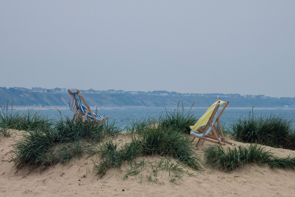 deckchairs on a sandy beach in summertime